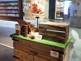 un présentoir composé de caisses en bois recouvertes d'herbe verte