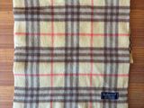 a plaid blanket on a wooden table with a tag on it