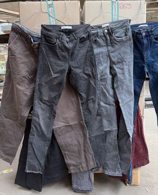 plusieurs paires de jeans suspendues à une corde à linge devant des cartons