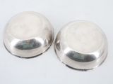 pair of silver plated salt and pepper shakers on a white surface