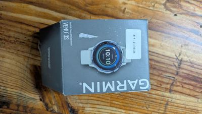 a box with a watch on it sitting on a wooden table