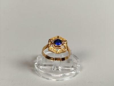 an image of a gold ring with a blue stone in the center