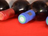several bottles of wine are lined up on a red cloth
