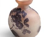 un vase orné d'un motif floral sur une surface blanche