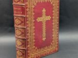 an old book with a cross on top of it and a bookmark