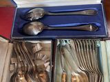 a lot of silver spoons and spoons in a box