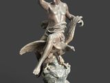 a statue of a woman sitting on a rock with a bird in her hand