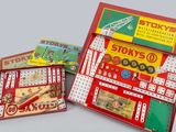 Plusieurs types de jouets différents se trouvent dans une boîte posée sur une surface grise.
