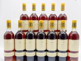 six bouteilles de vin sont alignées sur une surface blanche
