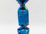 sculpture of a wrapped candy on a black base on a white background