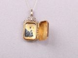 an image of a locke necklace with a picture of a dog inside