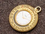 une montre de poche en or sur laquelle est gravé un poème