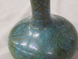 a blue and green vase sitting on a white surface
