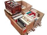 Plusieurs cartons de livres sont empilés sur des palettes, sur une palette