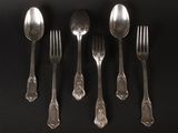 five silver spoons and a fork on a black surface