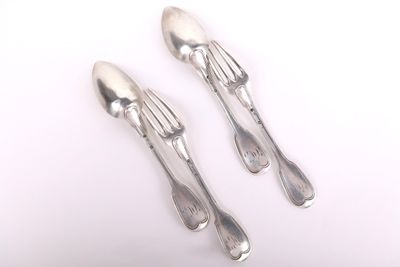 deux cuillères et une fourchette en argent sur une surface blanche
