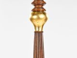 an image of a tall wooden candle holder with a gold colored base