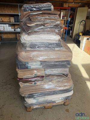 une grande pile de matelas posée sur une palette dans un entrepôt