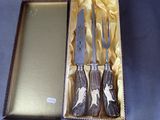 four knives in a box with a mirror in the background