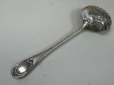 a silver spoon with a fan shaped handle on it