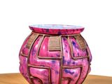 a pink vase sitting on top of a wooden table