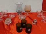 de nombreux verres et vases posés sur une table recouverte d'une nappe rouge