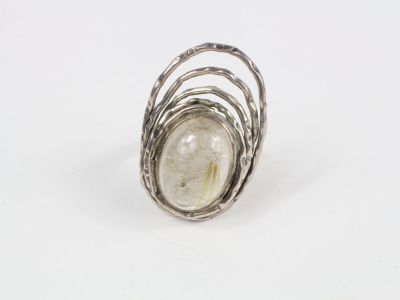 un gros plan d'une bague en argent sertie d'une pierre