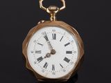 a gold pocket watch with roman numerals on the face