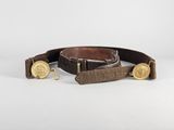 un gros plan sur une ceinture marron ornée de boutons dorés