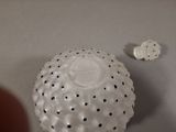 a white object with black dots on it and a white object with black dots on it