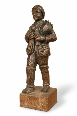 bronze statue of a man with a hat and jacket on a wooden base