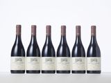 six bottles of red wine lined up in a row
