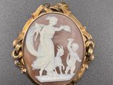 une broche en camée blanc et marron représentant une femme et un enfant
