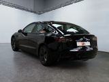 the back of a black tesla model 3 parked in a showroom