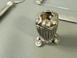 a small silver container with a teddy bear inside of it