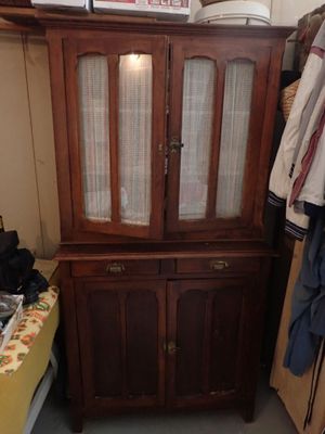 un meuble en bois avec une porte en verre dans une pièce