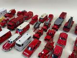 a lot of toy fire trucks and trucks on the table