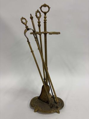 une photo d'une sculpture en bronze représentant trois balais posés sur un socle