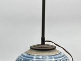 a blue and white vase with a light on it
