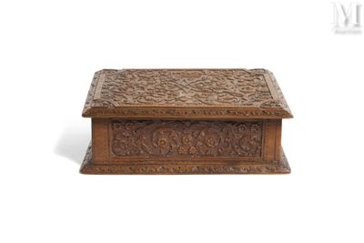 an old wooden box with carvings on it sitting on a white surface