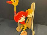 a wooden toy of a duck on a skateboard