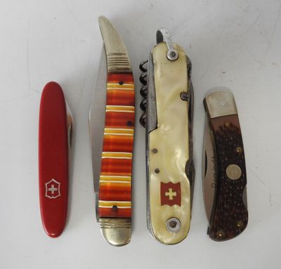 four different types of swiss army knives lined up on a white surface