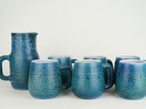five blue mugs sitting next to each other on a table