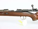 an old rifle with a wooden barrel and a keychain on a white background