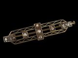un gros plan d'une broche en or et diamants sur fond noir
