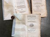 trois vieux livres posés sur une table l'un à côté de l'autre