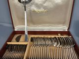 a lot of silver spoons and spoons in a case