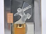 une image représentant une figurine en verre dans une boîte, posée sur une surface blanche