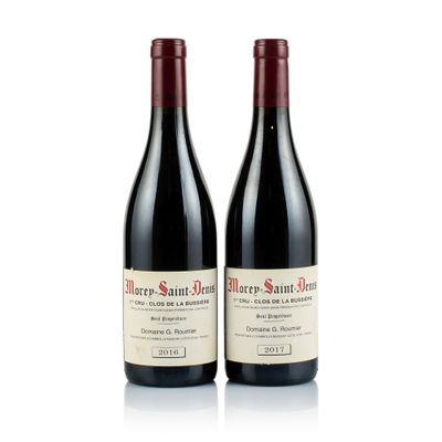 two bottles of red wine sitting next to each other on a white surface