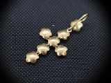 a close up of a pair of gold earrings on a black surface